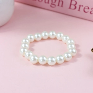 Detailed close-up of elegant white pearl beaded bracelet with a smooth glossy finish
