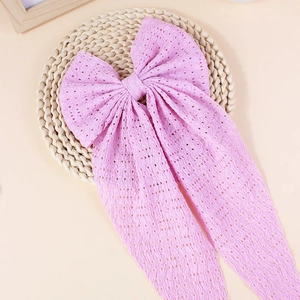 Détail du nœud papillon rose avec résille ajourée et de longs rubans fluides élégants