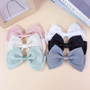 Lot de six barrettes à nœuds colorés faits main avec strass sur fond beige neutre