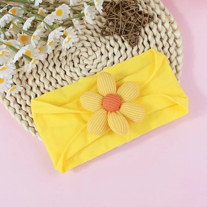 Détail d'un bandeau pour bébé avec une fleur jaune à cinq pétales sur fond tressé