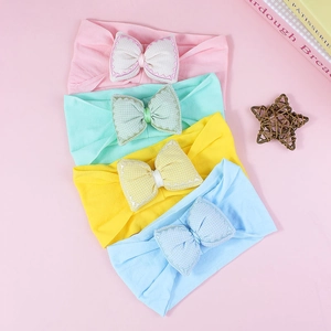 Pastel cotton baby headbands with large embroidered bows in pink, green, and yellow colors