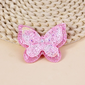 Dettaglio di farfalla in tessuto rosa a strati con paillettes e cuciture rifinite