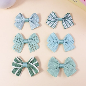 Set of 6 green handmade fabric bow accessories with diverse textures and patterns