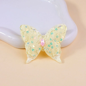 Detailed yellow lace butterfly accessory with sequins and a pink teardrop crystal bead