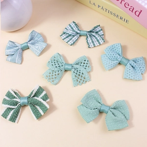 Set of six handmade green fabric bow accessories in lace, plaid, and jacquard styles
