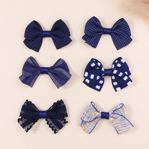 Set of 6 assorted navy blue fabric bow hair accessories in various patterns and textures