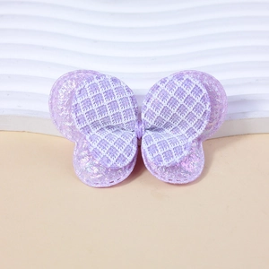 Macro detail of purple sequin butterfly bow with lace texture for DIY sewing projects