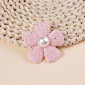 Dettaglio fiore in tessuto rosa imbottito con perla centrale e piccoli strass