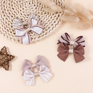 Handmade plaid fabric bow accessories in cream, purple and brown tones for DIY crafts