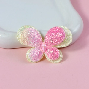 Close-up of pink glitter butterfly hair accessory with center gem and double-layered wings