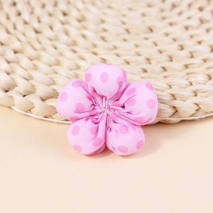 Detailed close-up of pink polka dot fabric flower handmade accessory for DIY crafts