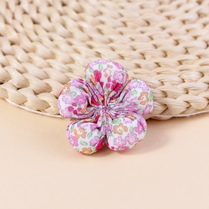Detailed view of handmade pink floral fabric flower for DIY hair accessories and crafts