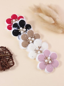 Detail of handmade corduroy flower accessories with faux fur edges and pearl centers
