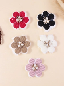 Close-up of corduroy flower accessories with white faux fur trim and pearl center
