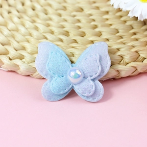 Detail of a double-layered sequin bow accessory with a pearl center for DIY crafts