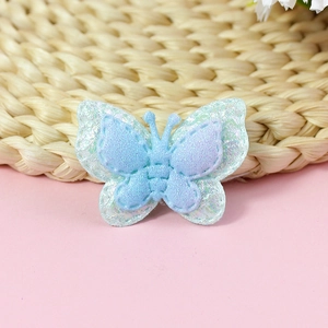Close-up of double-layer fabric butterfly patch with iridescent gradient blue glitter