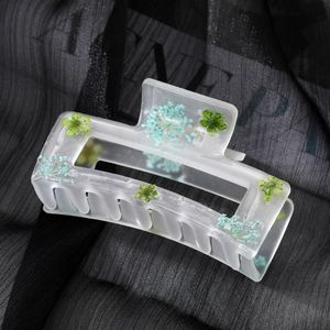 Frosted rectangular hair claw clip with embedded blue and green dried flowers
