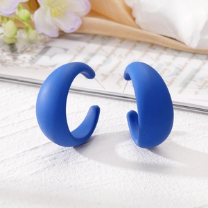 Boucles d'oreilles créoles géométriques en C bleu marine mat avec fond texturé élégant