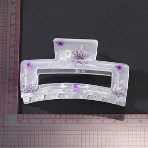 Detailed macro view of 8.5cm frosted hair claw clip with embedded purple dried flowers