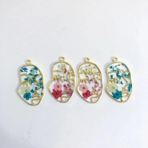 Artistic face-shaped earrings with colorful dried flowers in gold geometric metal frames