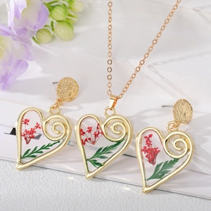 Vue macro détaillée de l'ensemble collier et boucles d'oreilles en résine de fleurs séchées