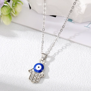 Dettaglio del ciondolo mano di Fatima con occhio greco blu e cristalli scintillanti