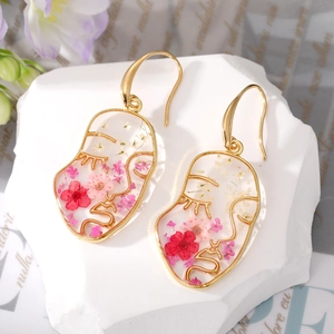 Abstract face-shaped earrings with colorful dried flowers in gold metal wire outline