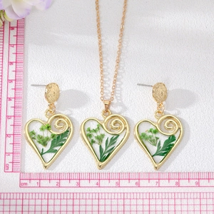 Vue détaillée de l'ensemble de bijoux coeur fleurs séchées avec règle de mesure