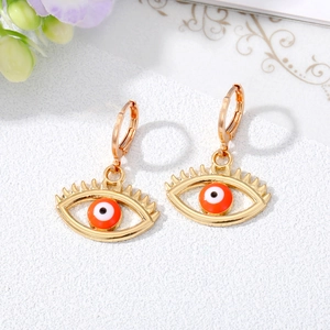 Macro shot of gold evil eye hoop earrings with colorful enamel and lash details