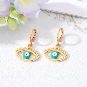 Detail of gold evil eye hoop earrings with blue stones and hollow eyelash design