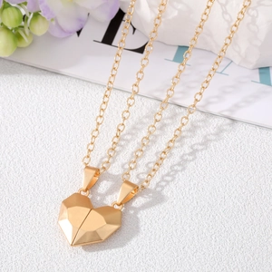 Detailed view of gold magnetic heart pendant necklaces on a stylized background