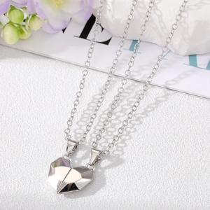 Close-up of magnetic heart-shaped split pendants with geometric faceted silver finish