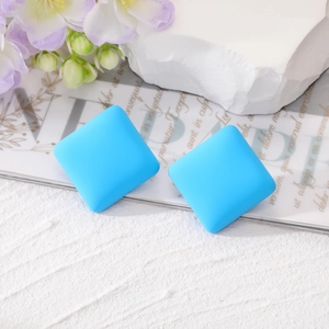 Square blue stud earrings with matte finish on white stone and purple flowers