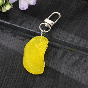 Realistic yellow citrus slice keychain with lifelike texture and silver metal clasp