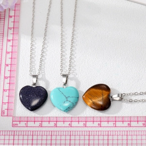 Close-up of heart-shaped stone necklaces in blue goldstone, turquoise, and tiger eye