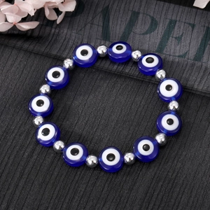 Détail du bracelet en perles avec yeux maléfiques bleus et perles en métal argenté