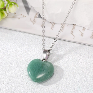 Macro shot of smooth heart-shaped green natural stone pendant on silver chain necklace