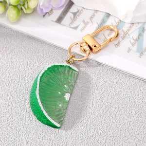 Detail shot of realistic green lime slice keychain with golden metal clasp and ring