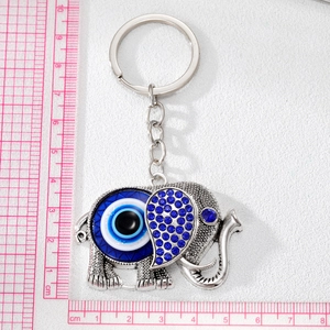 Vintage elephant keychain with evil eye design and blue rhinestones on white background