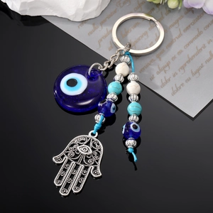 Porte-clés main de Fatma et œil bleu en verre avec perles tribales sur surface noire polie