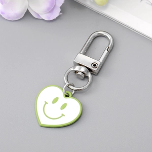 Détail d'un porte-clés en forme de cœur vert avec smiley et fermoir en D argenté