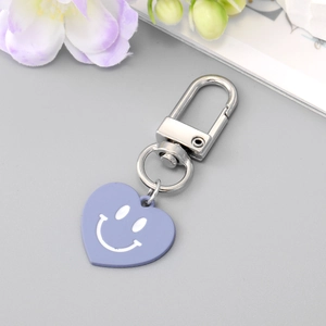 Porte-clés cœur violet mignon avec fermoir en D argenté sur un fond de fleurs douces