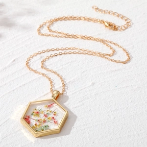 Collier hexagonal en résine avec fleurs séchées colorées et chaîne dorée fine