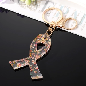 Detailed macro view of ribbon-shaped resin keychain filled with colorful dried flowers