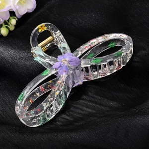 Transparent resin hair claw clip with embedded purple dried flowers and gold spring