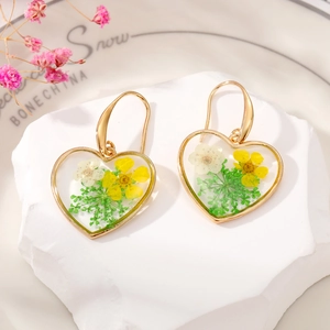 Handmade heart-shaped dried flower earrings with yellow daisies and gold hooks