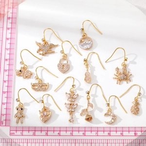 Set of 13 gold alloy drop earrings with rhinestones including butterfly and rose motifs