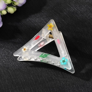Frosted resin triangle hair claw clip featuring embedded natural dried flowers and leaves