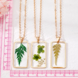Collier bohème avec pendentif rectangulaire en résine et fleurs séchées dorées