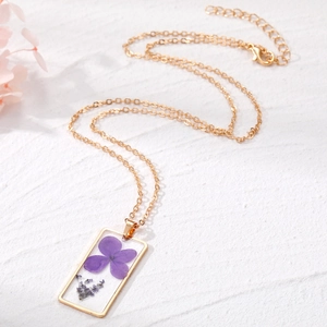 Collier bohème doré avec pendentif carré en résine contenant de véritables fleurs séchées mauves